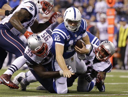 Indianapolis Colts quarterback Andrew Luck (12) is sacked by New England Patriots defensive end Chandler Jones (95) and defensive tackle Dominique Easley (99) in the second half of an NFL football game in Indianapolis, Sunday, Oct. 18, 2015. New England won 34-27. (AP Photo/John Minchillo)