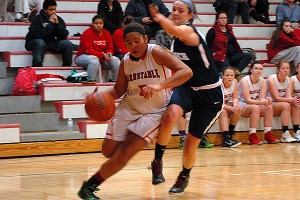 Barnstable's Mia Crawley (5) poured in 18 points last night, seen here driving the lane versus Sandwich High's Caroline Wilson, but the Blue Knights prevailed in overtime, 46-43. Sean Walsh/capecod.com sports
