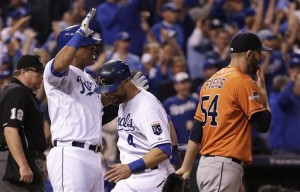 Kansas City Royals' Alex Gordon, center, and Salvador Perez, left, celebrate in front of Houston Astros pitcher Mike Fiers, right, after scoring on a double by teammate Alex Rios during the fifth inning of Game 5 in baseball's American League Division Series, Wednesday, Oct. 14, 2015, in Kansas City, Mo.  (AP Photo/Charlie Riedel)