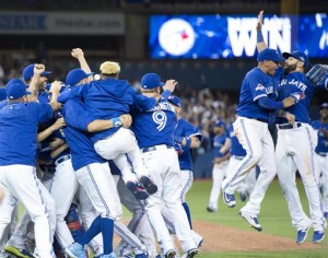 The Toronto Blue Jays celebrate after winning  Game 5 of baseball's American League Division Series against the Texas Rangers, Wednesday, Oct. 14, 2015, in Toronto. The Blue Jays clinched their first trip to the American League Championship Series since 1993, overcoming one of the most bizarre plays in playoff history by taking advantage of three Rangers errors for a 6-3 victory.  (Frank Gunn/The Canadian Press via AP) MANDATORY CREDIT