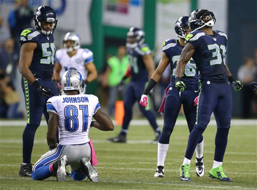 Seattle Seahawks strong safety Kam Chancellor, right, celebrates his tackle of Detroit Lions wide receiver Calvin Johnson in the second half of an NFL football game, Monday, Oct. 5, 2015, in Seattle. The Seahawks beat the Lions 13-10. (AP Photo/Scott Eklund)