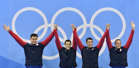 From right United States' Caeleb Dressel, Michael Phelps, Ryan Held, and Nathan Adrian, celebrate in the medals ceremony after winning gold in the men's 4 x 100-meter freestyle relay final during the swimming competitions at the 2016 Summer Olympics, Monday, Aug. 8, 2016, in Rio de Janeiro, Brazil. (AP Photo/Martin Meissner)
