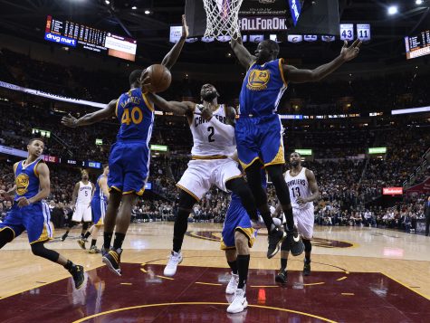 Cleveland Cavaliers guard Kyrie Irving (2) drives between Golden State Warriors forward Harrison Barnes (40) and Draymond Green (23) during the second half of Game 3 of basketball's NBA Finals in Cleveland, Thursday, June 9, 2016. Cleveland won 120-90. (Larry W. Smith/EPA via AP, Pool)