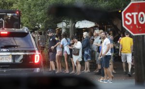 People watch the presidential motorcade as it maneuvers between narrow streets of downtown Oak Bluffs, Mass., on Martha's Vineyard, Sunday, Aug. 7, 2016. President Barack Obama and first lady Michelle Obama who are on a family vacation on the Massachusetts island of Martha's Vineyard are dining out with friends. (AP Photo/Manuel Balce Ceneta)