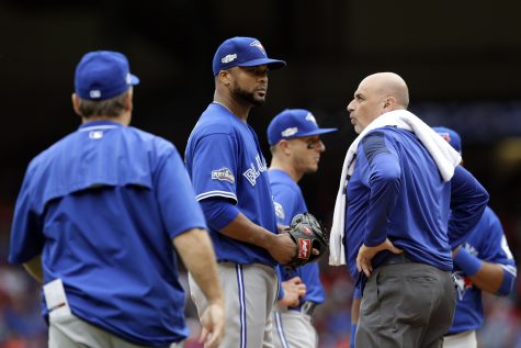 Toronto Blue Jays manager John Gibbons, left, and a member of the staff, right, check on relief pitcher Francisco Liriano after Liriano was hit on the back of the head by a single off the bat of Texas Rangers' Carlos Gomez in the eighth inning of Game 2 of baseball's American League Division Series, Friday, Oct. 7, 2016, in Arlington, Texas. Liriano was pulled from the game after the incident. (AP Photo/LM Otero)
