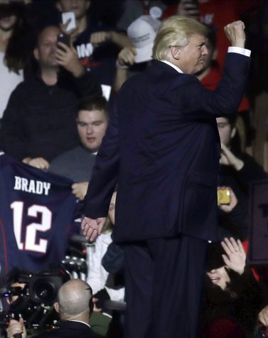 A supporter holds a jersey for New England Patriots quarterback Tom Brady, left, as Republican presidential candidate Donald Trump leaves the stage after a campaign rally, Monday, Nov. 7, 2016, in Manchester, N.H. (AP Photo/Charles Krupa)