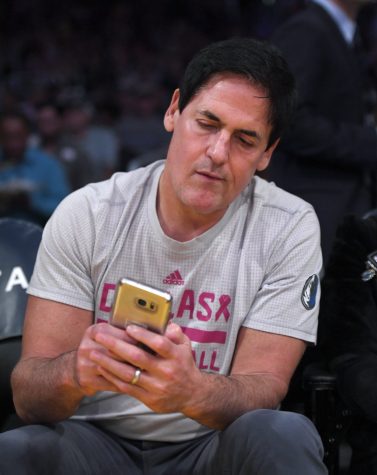 Dallas Mavericks owner Mark Cuban looks at election results during the first half of an NBA basketball game between the Los Angeles Lakers and the Mavericks, Tuesday, Nov. 8, 2016, in Los Angeles. (AP Photo/Mark J. Terrill)