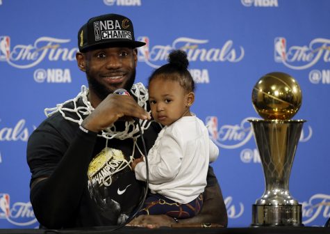 Cleveland Cavaliers' LeBron James answers questions as he holds his daughter Zhuri during a post-game press conference after Game 7 of basketball's NBA Finals Sunday, June 19, 2016, in Oakland, Calif. Cleveland won 93-89. (AP Photo/Eric Risberg)