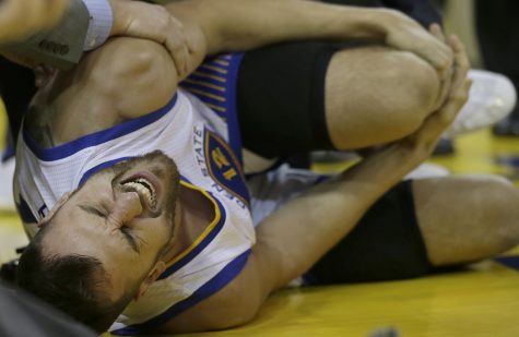 Golden State Warriors center Andrew Bogut grabs his leg during the second half of Game 5 of basketball's NBA Finals against the Cleveland Cavaliers in Oakland, Calif., Monday, June 13, 2016. (AP Photo/Marcio Jose Sanchez)