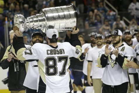 Pittsburgh Penguins center Sidney Crosby (87) hands the Stanley Cup to defenseman Trevor Daley after Game 6 of the NHL hockey Stanley Cup Finals against the San Jose Sharks in San Jose, Calif., Sunday, June 12, 2016. The Penguins won 3-1 to win the series 4-2. (AP Photo/Marcio Jose Sanchez)
