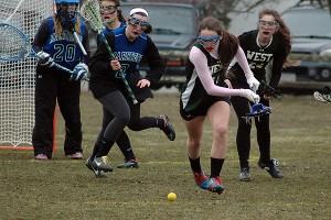Sturgis West's Rachel Kilduff goes after a loose ball in front of the Mariners' goalie Kenzie Rogers as defender Moira Nunley (2) and West's Amanda Bagnardi (24) come from behind in yesterday's 18-4 win for the Academy. Sean Walsh/Capecod.com Sports Photos