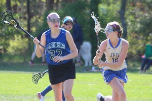Falmouth Academy's Charlotte Van Voorhis tries to get away from St. John Paul II's Kyra McCabe in Monday's girls' lacrosse action at Sandy Pond. Phil Garceau/Capecod.com Sports