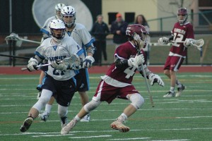 Falmouth sophomore midfielder Nolan Enneguess races away from Blue Knight TJ Cairns in last night's 11-10 overtime win for the hosts. Sean Walsh/Capecod.com Sports Photos