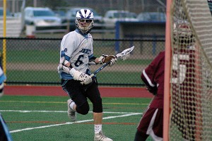 Sandwich High's Zach Gorassi hones in on Falmouth freshman goalie Dylan McDonald before sending it past him for a goal. Sandwich won in overtime, 11-10. Sean Walsh/Capecod Sports Photos