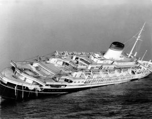 The Italian luxury liner Andrea Doria keels far over to starboard before sinking 225 feet to the bottom of the Atlantic 45 miles off Nantucket Island, Ma., July 26, 1956. The Andrea Doria was struck broadside by the Swedish-American liner Stockholm in heavy fog July 25 at 11:10 p.m.. (AP Photo/John Rooney)