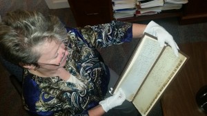 CCB MEDIA PHOTO Barnstable Town Clerk Ann Quirk displaying a ledger from the 1700s.