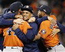 Houston Astros center fielder Carlos Gomez, center, embraces Astros relief pitcher Luke Gregerson (44) as Luis Valbuena joins in the celebration after the Astros shutout the New York Yankees 3-0 in the American League wild card baseball game at Yankee Stadium in New York, Tuesday, Oct. 6, 2015.  (AP Photo/Kathy Willens)