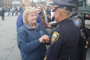 CCB MEDIA PHOTO Gail McCarthy shakes hands with a "thin blue line" of police officers Saturday, November 7th at the second Cape Cod Cares for Our Cops rally of the year