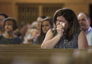 Parishioner Christine Kane, of Pembroke, Mass., front, cries during a planned final service at St. Frances X. Cabrini Church, Sunday, May 29, 2016, in Scituate. For more than 11 years, a core group of about 100 die-hard parishioners at the church have kept their parish open by maintaining an around-the-clock vigil in protest of a decision by the Roman Catholic Archdiocese of Boston to close it following the clergy sex abuse crisis. (AP Photo/Steven Senne)