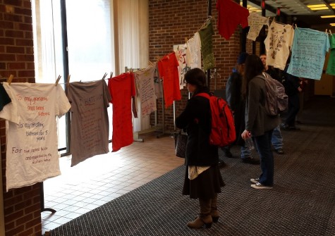 CCB MEDIA PHOTO Cape Cod Community College students viewing the Cape Cod Clothesline Project which was on display in the lobby of the Tilden Arts Center on Tuesday.