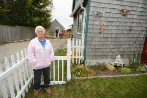 CCB MEDIA PHOTO Betsey Tracey, a 75-year resident of Buzzards Bay and who grew up in the same Taylor Road home pictured, stands while volunteers perform various work on her yard and home during the 2015 Big Fix