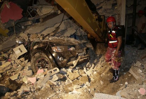 A rescue worker searches in the rubble of a destroyed house in the Pacific coastal town of Pedernales, Ecuador, Sunday, April 17, 2016. The strongest earthquake to hit Ecuador in decades flattened buildings and buckled highways along its Pacific coast, sending the Andean nation into a state of emergency. (AP Photo/Dolores Ochoa)