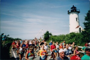 COURTESY PAUL CLERICI Runners pass by Nobska Point Lighthouse in this photo by Paul Clerici, author of a new history of the Falmouth Road Race.