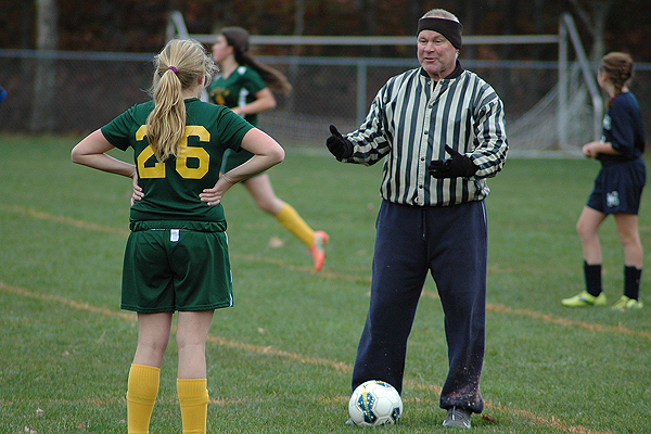 Middle and high school referee, umpire and game official Keith Forker has been officiating local games for decades, seen here last fall instructing an 8th grade soccer player in Yarmouth during a penalty call. Photo by Sean Walsh/CCB Media Sports