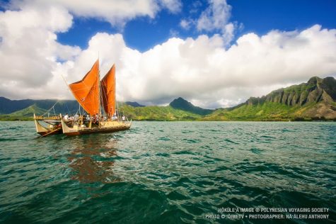 The day breaks over Hōkūleʻa with Kualoa Hawaii behind her.
