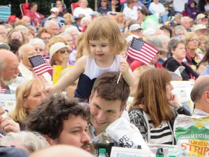 A young girl waves American flags during the 30th Annual Pops By The Sea Concert in Hyannis