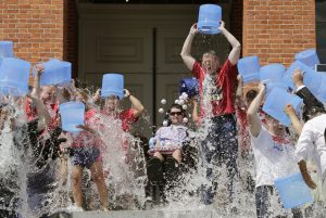 Massachusetts Gov. Charlie Baker, right center, and Lt. Gov. Karyn Polito, third from left, participate in the Ice Bucket Challenge with its inspiration Pete Frates, seated in center, to raise money for ALS research, Monday, Aug. 10, 2015, at the Statehouse in Boston. (AP Photo/Charles Krupa)