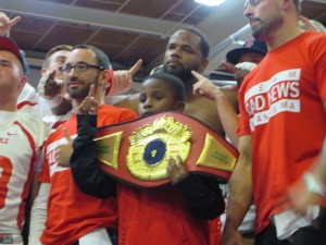 CCB MEDIA PHOTO Northeast Heavyweight Champion Jesse Barboza raises his belt Saturday after successfully defending his title against Francisco Mireles of Mexico. Members of the Barnstable High School football team joined Barboza in the ring after his victory