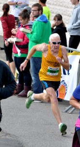 COURTESY MickFoto/NERunner Larry Cole runs to the finish line at the Paddy's Shillelagh Shuffle three-mile race in West Newton in October 2014. It is the last of the six races in the New England Runner Pub Series. It is also a benefit for Athletes Unlimited, a local charity for children with special needs.