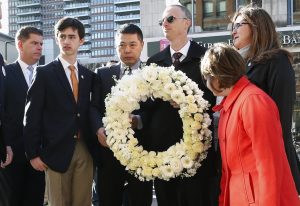 Family members of Boston Marathon bombing victim Martin Richard, Bill, third from right, Denise, right, Jane, second from right, and Henry, second from left, along with the father of victim Lingzi Lu, Jun Lu, third from left, and Boston Mayor Marty Walsh, left, prepare to place a wreath on the third anniversary of the bombings, Friday, April 15, 2016, in Boston. (AP Photo/Michael Dwyer)