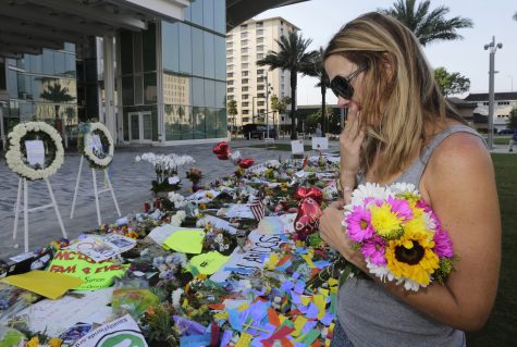 Amy Semesco wipes a tear as she pays tribute, Tuesday, June 14, 2016, in Orlando, Fla., at a growing memorial at the The Dr. Phillips Center for the victims of the mass shooting Sunday at the Pulse Nightclub. (AP Photo/Alan Diaz)
