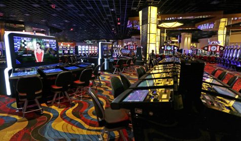 Slot machine lights glow on the floor of the Plainridge Park Casino in Plainville, Mass. (AP Photo/Charles Krupa)