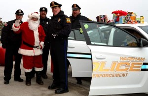 Wareham police officers and Santa at their 2013 stuff-a-cruiser event. Photo Credit: warehampolice.com
