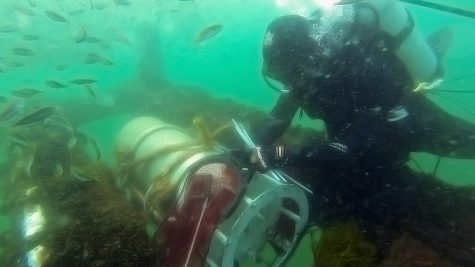 MIT/WHOI Joint Program student Bennett Lambert assists with deploying FlowCytobot (FCB) at the WHOI-operated Martha’s Vineyard Coastal Observatory. Underwater connections to FCB supply power and real-time two-way communication at this ocean observatory (Photo by Sean Whelan, Woods Hole Oceanographic Institution)