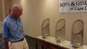 CCB MEDIA PHOTO Centerville resident Paul Ruane admiring the Red Sox 2004, 2007 and 2013 World Series Trophies on Monday at New Seabury Country Club in Mashee before the 18th annual Boys and Girls of Cape Cod Golf Tournament.
