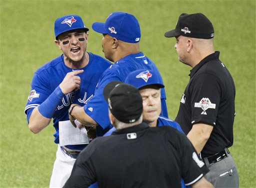 Toronto Blue Jays' Troy Tulowitzki, left, is held back by bench coach DeMarlo Hale as he argues with the home plate umpire over being ejected during the eighth inning in Game 3 of baseball's American League Championship Series against the Kansas City Royals on Monday, Oct. 19, 2015, in Toronto. (Darren Calabrese/The Canadian Press via AP) MANDATORY CREDIT