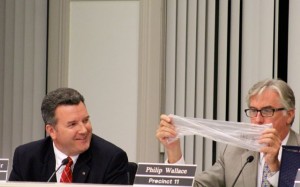 CCB MEDIA PHOTO Barnstable Town Councilor Philip Wallace shows what he found littering local streets, while Councilor Eric Steinhilber looks on. A majority of town councilors voted to ban plastic bags by a vote of 7 to 6. Both Wallace and Steinhilber voted against the measure.