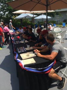 PHOTO BY HANNAH BABINEAU. Players keep busy autographing for fans during Baseball Day at the Cape Codder.