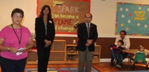 CCB MEDIA PHOTO Bridget Delaney-Messana, Director of Child Care Services at Cape Cod Child Development, speaks at the grand opening of the agency's new center in Teaticket, as Anne Colwell, CEO of Cape Cod Child Development, and State Representative David Vieira, listen.