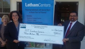 Latham Centers CEO Anne McManus (far right) and Board Chair Jeni Landers accept a $3 million check from Scott Soares from USDA Rural Development.
