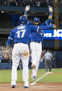 Toronto Blue Jays Jose Bautista celebrates with teammate Ryan Goins after hitting a three-run home run during the seventh inning in Game 5 of baseball's American League Division Series, Wednesday, Oct. 14, 2015 in Toronto. The Toronto Blues Jays beat the Texas Rangers 6-3. (Frank Gunn/The Canadian Press via AP) MANDATORY CREDIT