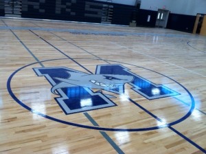 The school symbol graces the center of the new gym.
