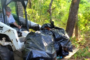 CCB MEDIA NEWS A Bobcat is loaded with trash cleared from homeless camps in the Hyannis woods.