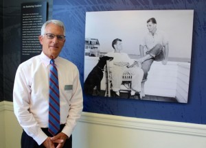 CCB MEDIA PHOTO John Allen, executive director of the John F. Kennedy Hyannis Museum, poses in front of the final photo in the special exhibit, "Jack & Bobby: Brothers First."