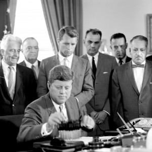 Cecil Stoughton/White House, John F. Kennedy Presidential Library and Museum, Boston /COURTESY JOHN F. KENNEDY HYANNIS MUSEUM President John F. Kennedy signs the Anti-Crime Act in 1961 in the Oval Office at the White House. Standing behind him are Senator Kenneth B. Keating (left); Director, FBI, J. Edgar Hoover; Attorney General Robert F. Kennedy; and three unidentified men. 