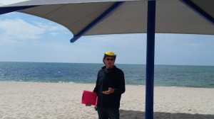 CCB MEDIA PHOTO Bob Kohl explains the virtues of sun protection at the installation of a new large umbrella at Bass River Beach. Kohl is the father of Glenna Kohl, a Barnstable High School graduate who died of melanoma at the age of 26.